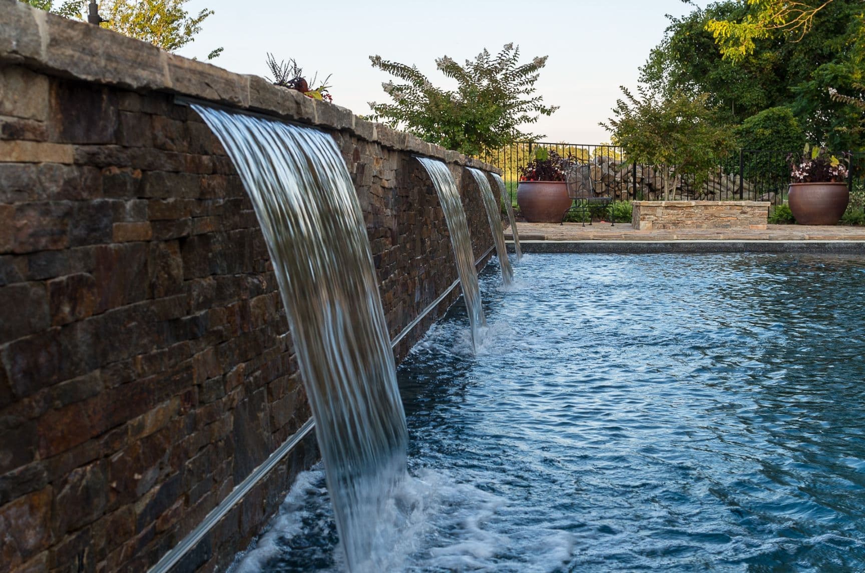 Stone waterfall wall and luxury pool built by Field of Dreams