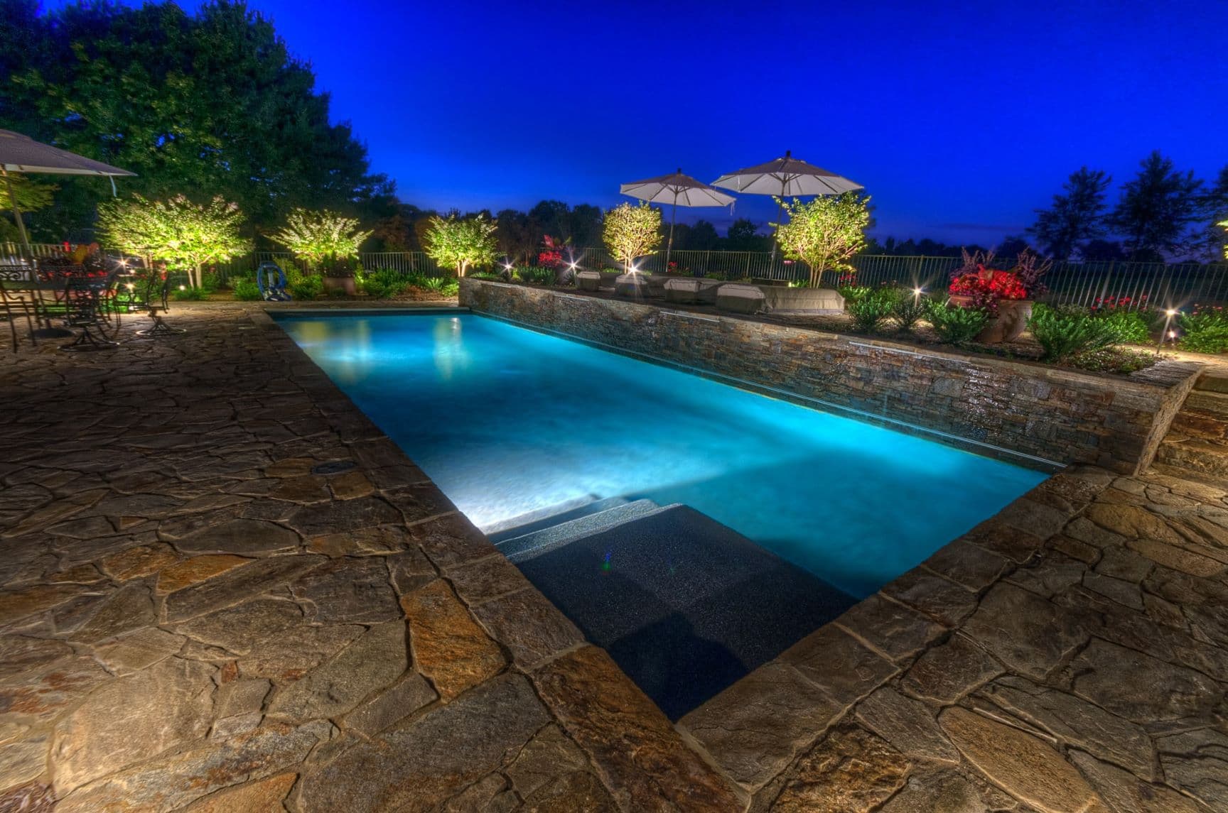 Custom luxury backyard pool and stone deck by Field of Dreams