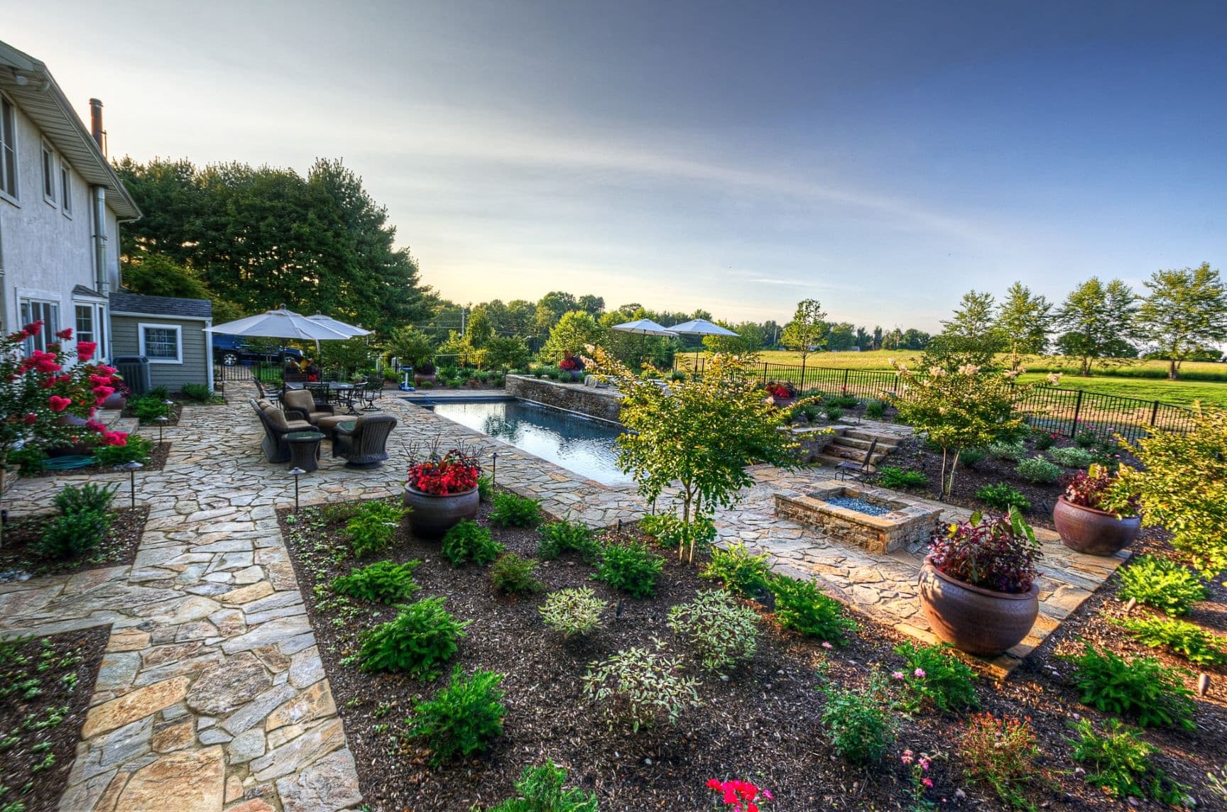 Custom luxury backyard pool and stone deck by Field of Dreams