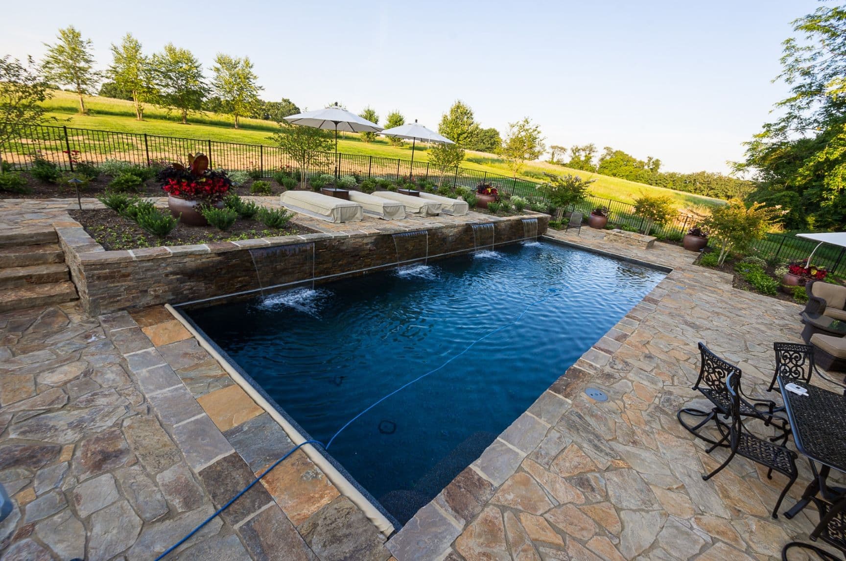 Custom luxury backyard pool and stone deck by Field of Dreams