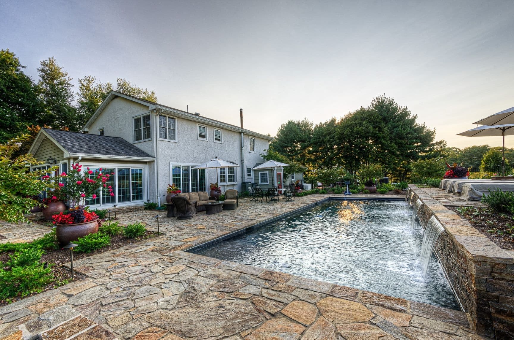 Custom luxury backyard pool and stone deck by Field of Dreams